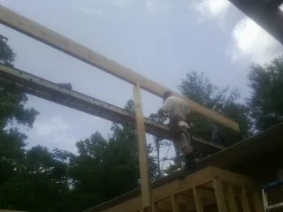Carpenter setting a ridge beam over a new addition frame — Ice Dam Removal by Roofing Brothers in East Quogue