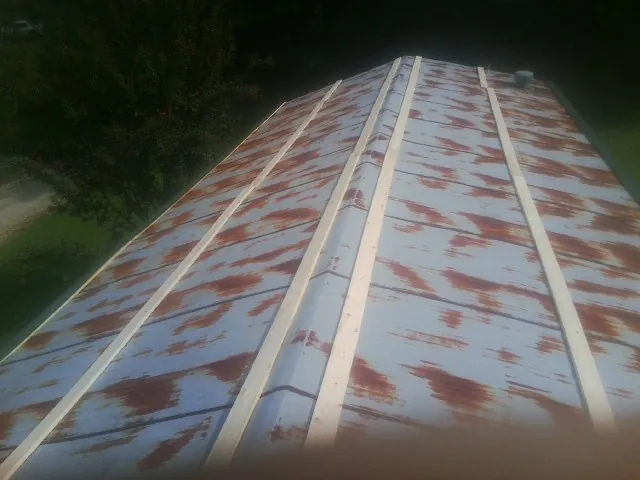 Rusted metal roof panels with new wood purlins before replacement — Storm Damage Roof Repair in East Quogue by Roofing Brothers
