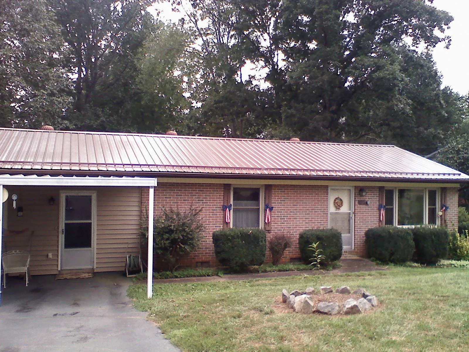 Bronze metal roof and carport on a brick ranch home — Roof Repair work by our crew in East Quogue